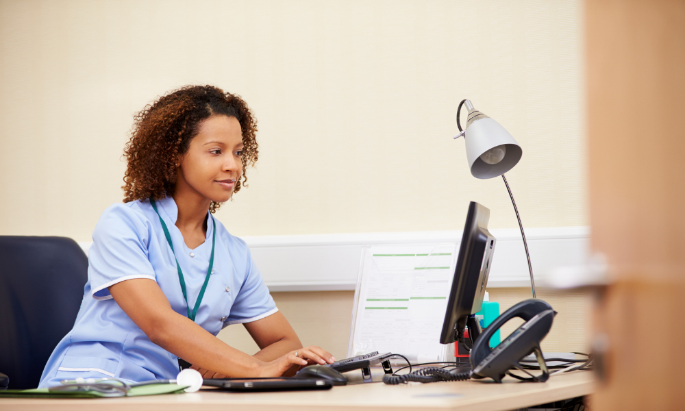 Nurse Looking at Computer in Office